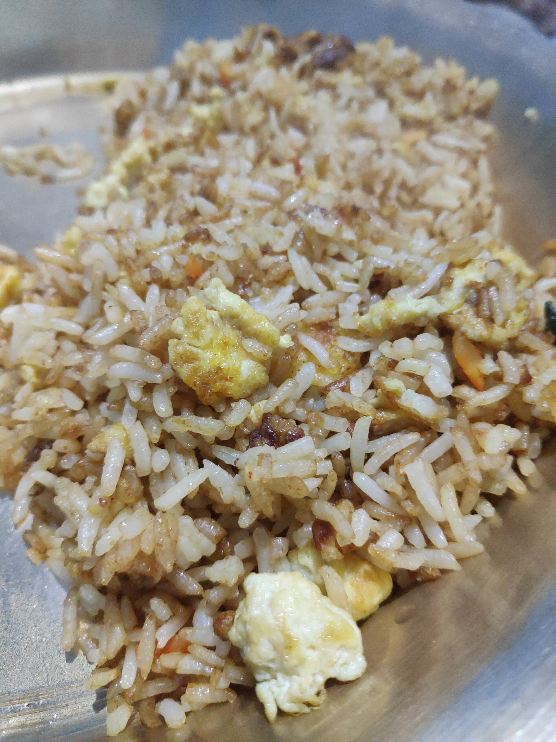 A plate of egg fried rice with visible pieces of egg and onion